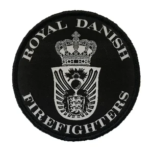 Rundt broderet sort "Royal Danish Firefighters"-mærke med et hvidt emblem af en krone og våbenskjold i midten.